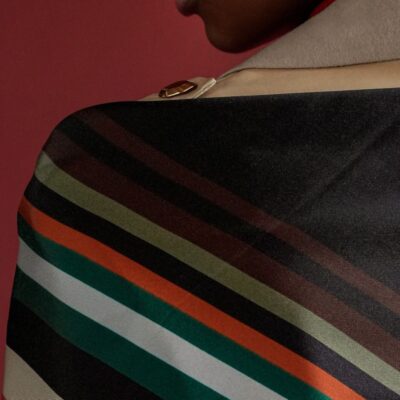 Scialle di seta su una spalla, con righe colori autunnali
